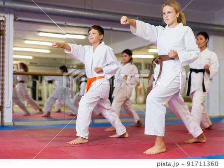 Boys and girls are studying karate technique in gym 91711360