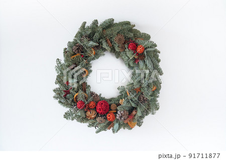 Christmas Holiday Wreath Isolated On White Background. Wreath made of natural fir branches hanging with natural ornaments: bumps, cones, garlands, stars. Christmas Holiday Wreath Isolated On White Background. Wreath made of natural fir branches hanging with natural ornaments: bumps, cones, garlands, stars. 91711877