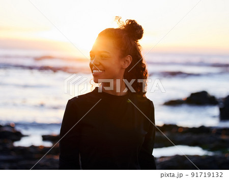 Change your thoughts and you change your life. Shot of an attractive young woman standing alone after doing yoga on the beach at sunset. 91719132
