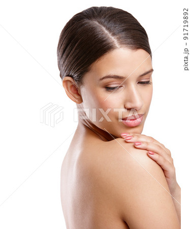Shes got silky smooth skin. Studio shot of a beautiful young woman looking over her shoulder against a white background. Shes got silky smooth skin. Studio shot of a beautiful young woman looking over her shoulder against a white background. 91719892