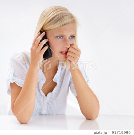 This cant be true. Shot of an attractive woman looking worried while talking on her cellphone. 91719990