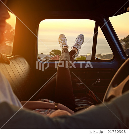 Take a break, you deserve it. Shot of a young woman relaxing on her boyfriends lap with her feet up during a road trip. Take a break, you deserve it. Shot of a young woman relaxing on her boyfriends lap with her feet up during a road trip. 91720308