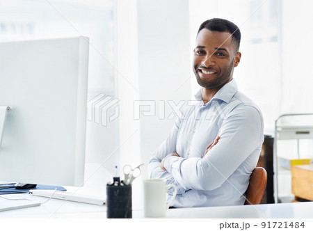 Hes confident in his career. A handsome young african american businessman working at his desk. Hes confident in his career. A handsome young african american businessman working at his desk. 91721484