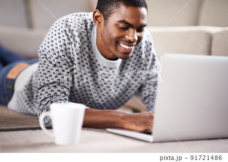 Having coffee with a friend. Cropped shot of a handsome young man using his laptop while relaxing at home. Having coffee with a friend. Cropped shot of a handsome young man using his laptop while relaxing at home. 91721486