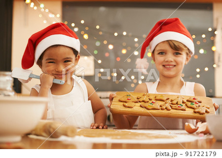 We made these Christmas cookies. Portrait of two little girls baking in the kitchen. 91722179