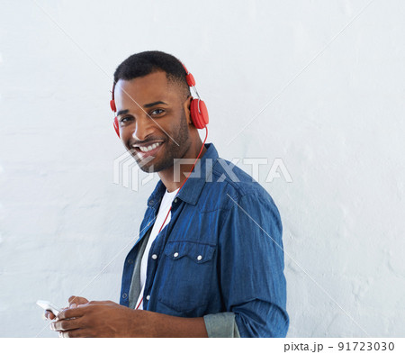 What an awesome track. A young african american man wearing a headphones and listening to music against a white background. What an awesome track. A young african american man wearing a headphones and listening to music against a white background. 91723030