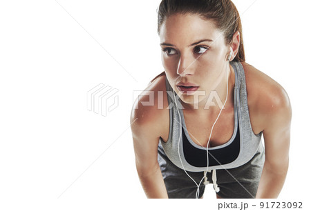 Motivated by music. Cropped shot of a young female athlete listening to music against white background. 91723092