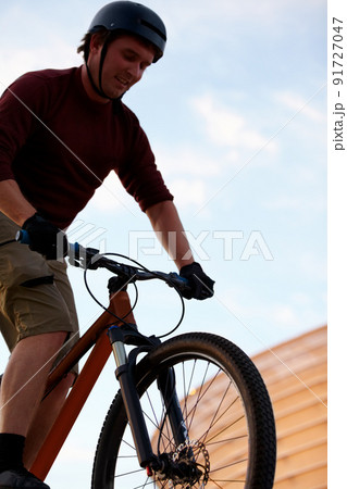 Practice, practice, practice. Low angle shot of a man doing tricks on his bike. Practice, practice, practice. Low angle shot of a man doing tricks on his bike. 91727047
