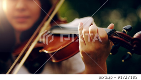 Music lifts the spirit and enlightens the soul. Cropped shot of an unrecognizable teenage girl playing a violin outside. 91727185