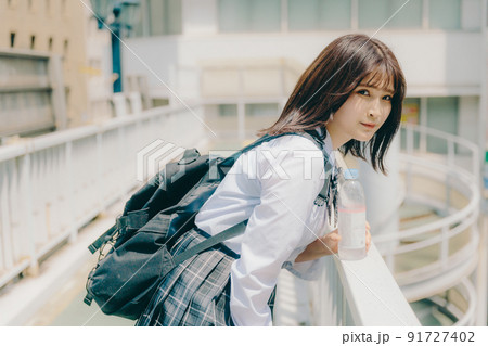 制服姿の女子高生と街並み 91727402
