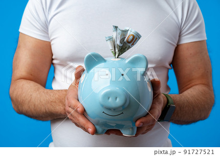 Close up of man holding piggy bank, saving money for investment 91727521