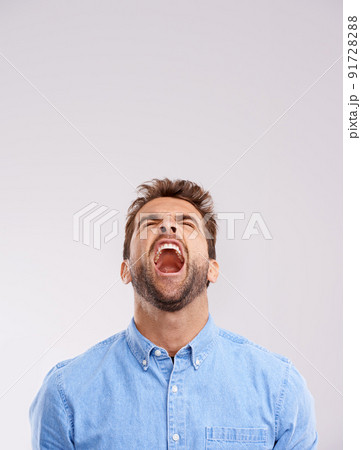 Theres no hiding his feelings. Studio shot of a handsome young man screaming in anger against a gray background. 91728288