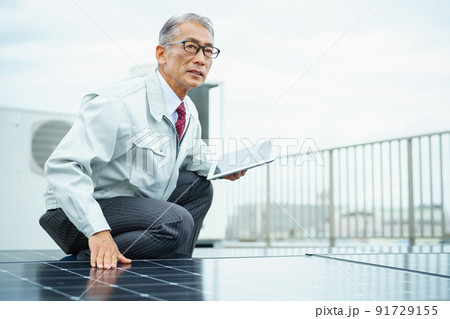 ソーラーパネルを点検するビジネスマン 91729155