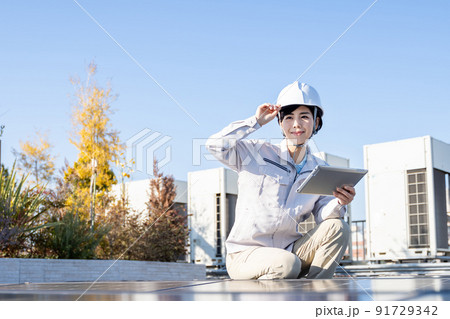 ソーラーパネルをチェックする女性作業員 ソーラーパネルをチェックする女性作業員 91729342