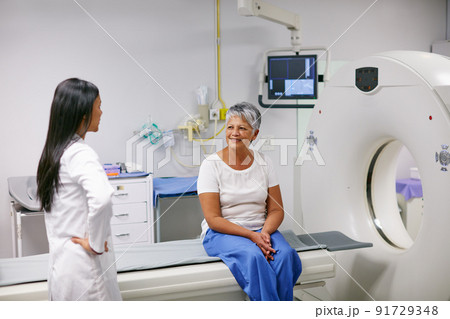 Let me explain how this works.... Shot of a senior woman talking with a doctor before and MRI scan. 91729348