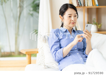 ミドル女性 スマホ リビング ミドル女性 スマホ リビング 91729590