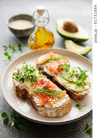 Sandwiches with salted salmon, avocado and microgreens. Sandwiches with salted salmon, avocado and microgreens. 91731684