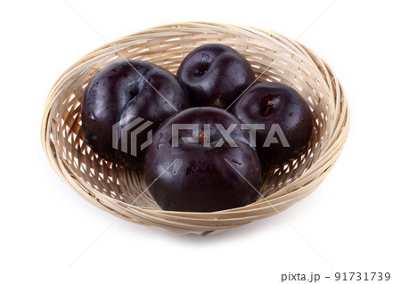 Plums on wicker plate 91731739