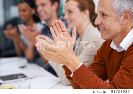 Hes proud of his young up and comers. Cropped shot of a handsome mature businessman sitting amongst his coworkers. 91731987
