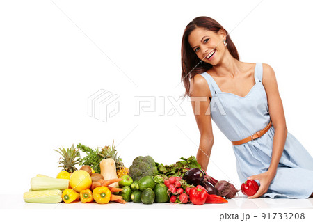 Making healthy choices and feeling great. Smiling young woman alongside an assortment of healthy and fresh vegetables. Making healthy choices and feeling great. Smiling young woman alongside an assortment of healthy and fresh vegetables. 91733208