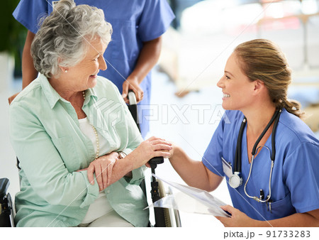 Cropped shot of an attractive female nurse discussing treatments with her wheelchair-bound senior patient in the hospital Cropped shot of an attractive female nurse discussing treatments with her wheelchair-bound senior patient in the hospital 91733283