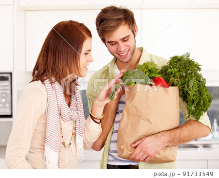Did you get everything. A young couple holding fresh groceries in the kitchen. Did you get everything. A young couple holding fresh groceries in the kitchen. 91733549