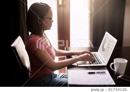 Working from home is more efficient for her. Cropped shot of an attractive young businesswoman working from home. Working from home is more efficient for her. Cropped shot of an attractive young businesswoman working from home. 91734130