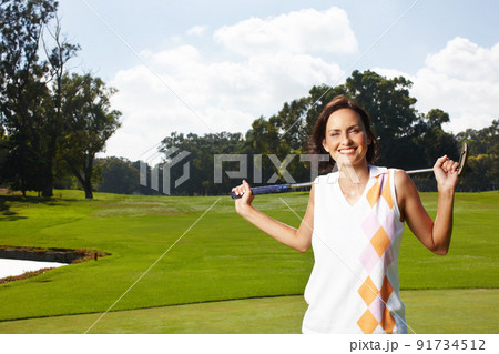 Golfs her favourite sport. Young woman standing on the golf course and holding her club over her shoulders. Golfs her favourite sport. Young woman standing on the golf course and holding her club over her shoulders. 91734512