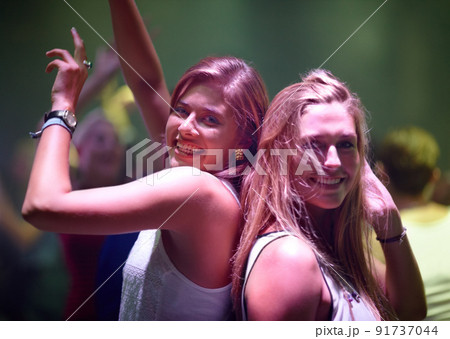 Letting loose at the club. A pretty young woman partying it up with friends in the club. Letting loose at the club. A pretty young woman partying it up with friends in the club. 91737044