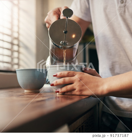 Say your good mornings and head for coffee. Cropped shot of an unrecognizable couple pouring their morning coffee. 91737187