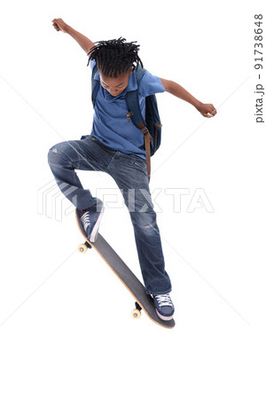 Showing off his mad skills. A young African-American boy doing a trick on his skateboard. 91738648