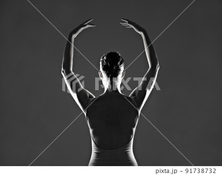 She lives to dance. Silhouette of a young ballerina dancing against a dark background. 91738732
