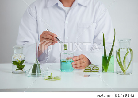 Plants and flowers extract in petri dish and a white background in laboratory , green leaf in a test tube and doctor for cosmetic advertising , photography science concept Plants and flowers extract in petri dish and a white background in laboratory , green leaf in a test tube and doctor for cosmetic advertising , photography science concept 91739142