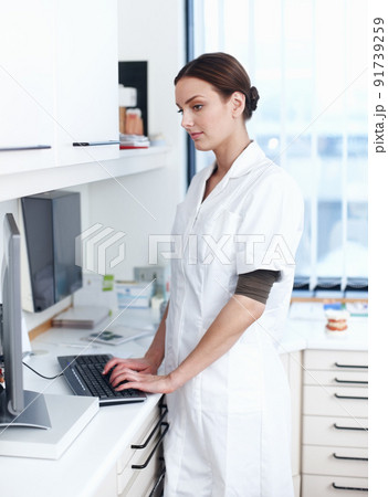 Female dentist using computer. Portrait of female dentist working on computer in office. Female dentist using computer. Portrait of female dentist working on computer in office. 91739259
