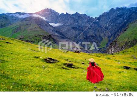 Tourist enjoy view of green pasture and flowers near Elia mountain in Georgia. 91739586