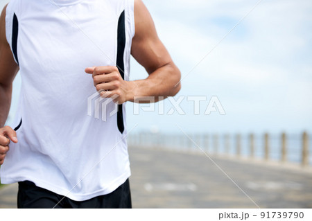 Push your body beyond its limits. Cropped image of a fit and athletic male running on a beach promenade outside - copyspace. Push your body beyond its limits. Cropped image of a fit and athletic male running on a beach promenade outside - copyspace. 91739790