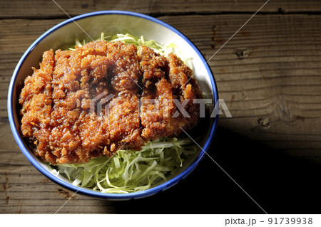 繊切りキャベツの上にたっぷりのソースが絡んだカツが乗っている熱々ソースかつ丼を俯瞰で撮影 91739938