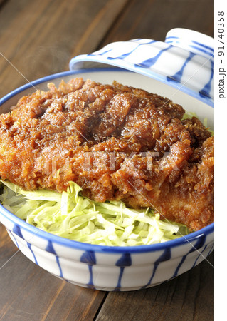 繊切りキャベツの上にたっぷりのソースが絡んだカツが乗っている熱々ソースかつ丼 91740358