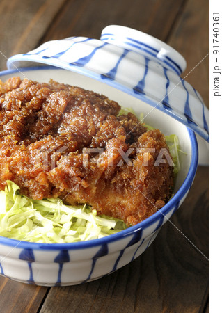 繊切りキャベツの上にたっぷりのソースが絡んだカツが乗っている熱々ソースかつ丼 91740361