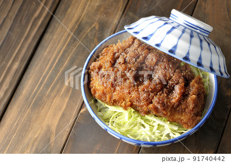 繊切りキャベツの上にたっぷりのソースが絡んだカツが乗っている熱々ソースかつ丼を俯瞰で撮影 91740442
