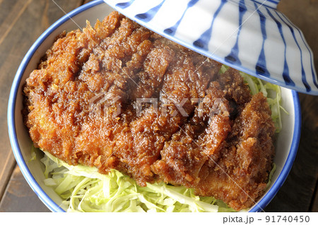 繊切りキャベツの上にたっぷりのソースが絡んだカツが乗っている熱々ソースかつ丼を俯瞰で撮影 91740450