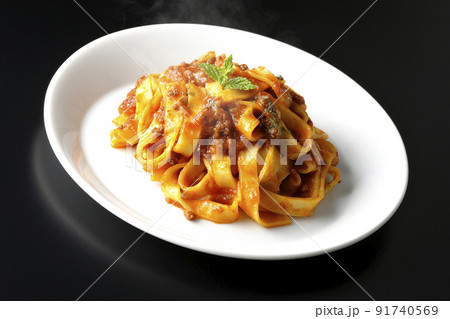 平打ちパスタのフィットチーネとトマトソースがよく絡んだ熱々ボロネーゼを黒背景で撮影 平打ちパスタのフィットチーネとトマトソースがよく絡んだ熱々ボロネーゼを黒背景で撮影 91740569
