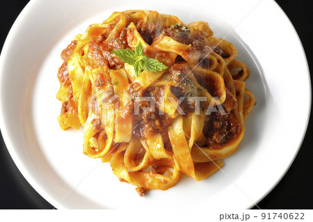 平打ちパスタのフィットチーネとトマトソースがよく絡んだ熱々ボロネーゼを黒背景で俯瞰撮影 平打ちパスタのフィットチーネとトマトソースがよく絡んだ熱々ボロネーゼを黒背景で俯瞰撮影 91740622