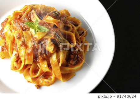 平打ちパスタのフィットチーネとトマトソースがよく絡んだ熱々ボロネーゼを黒背景で俯瞰撮影 平打ちパスタのフィットチーネとトマトソースがよく絡んだ熱々ボロネーゼを黒背景で俯瞰撮影 91740624