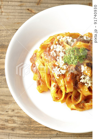 平打ちパスタのフィットチーネとトマトソースがよく絡んだボロネーゼにパルメザンチーズがけを俯瞰で撮影 91740930