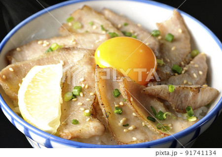 カットレモンと卵黄が乗った熱々豚トロ丼、焼き肉丼を黒背景で撮影 カットレモンと卵黄が乗った熱々豚トロ丼、焼き肉丼を黒背景で撮影 91741134