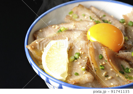 カットレモンと卵黄が乗った熱々豚トロ丼、焼き肉丼を黒背景で撮影 カットレモンと卵黄が乗った熱々豚トロ丼、焼き肉丼を黒背景で撮影 91741135