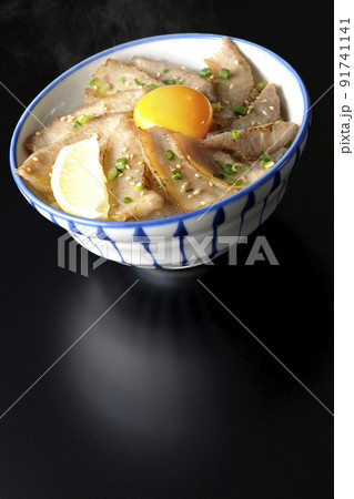 カットレモンと卵黄が乗った熱々豚トロ丼、焼き肉丼を黒背景で撮影 カットレモンと卵黄が乗った熱々豚トロ丼、焼き肉丼を黒背景で撮影 91741141