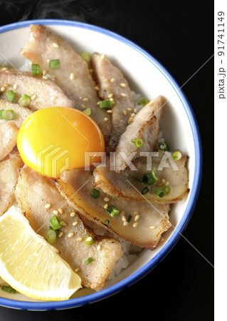 カットレモンと卵黄が乗った熱々豚トロ丼、焼き肉丼を黒背景で俯瞰撮影 カットレモンと卵黄が乗った熱々豚トロ丼、焼き肉丼を黒背景で俯瞰撮影 91741149