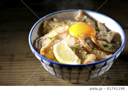 カットレモンと卵黄が乗った熱々豚トロ丼、焼き肉丼 カットレモンと卵黄が乗った熱々豚トロ丼、焼き肉丼 91741196